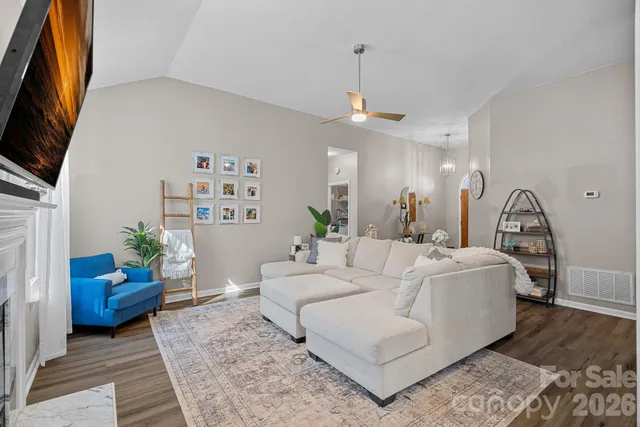 a kitchen with kitchen island granite countertop wooden floors and white cabinets