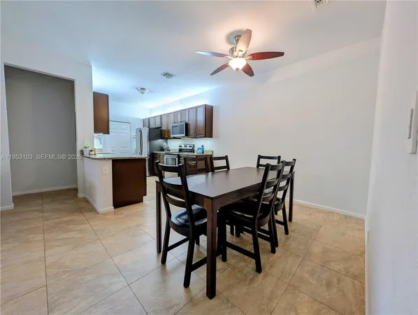 a view of a dining room with furniture and a chandelier fan