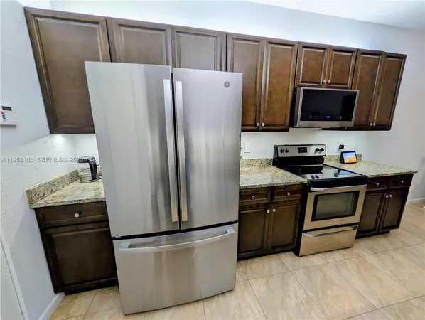 a kitchen with stainless steel appliances a refrigerator stove and microwave
