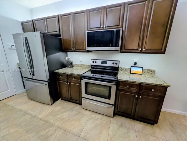 a kitchen with stainless steel appliances a stove microwave and refrigerator