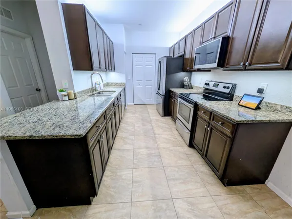 a kitchen with stainless steel appliances granite countertop a stove a sink and a microwave