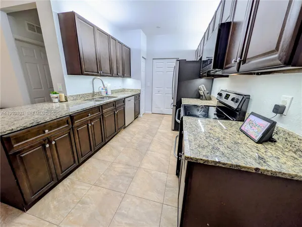 a kitchen with stainless steel appliances granite countertop a sink stove and cabinets
