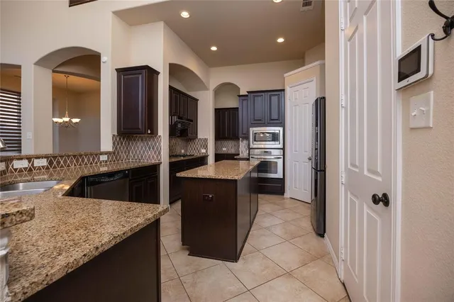 a kitchen with stainless steel appliances granite countertop a refrigerator and a sink
