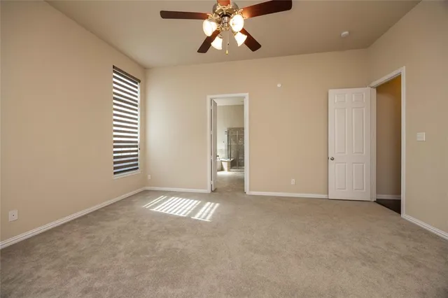 en empty room with windows and chandelier fan