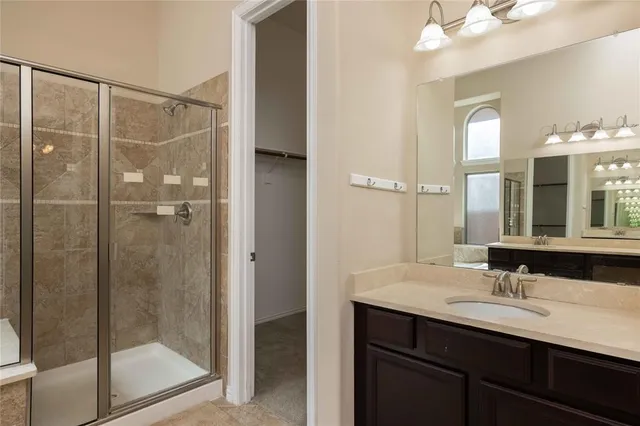 a bathroom with a shower sink vanity and mirror