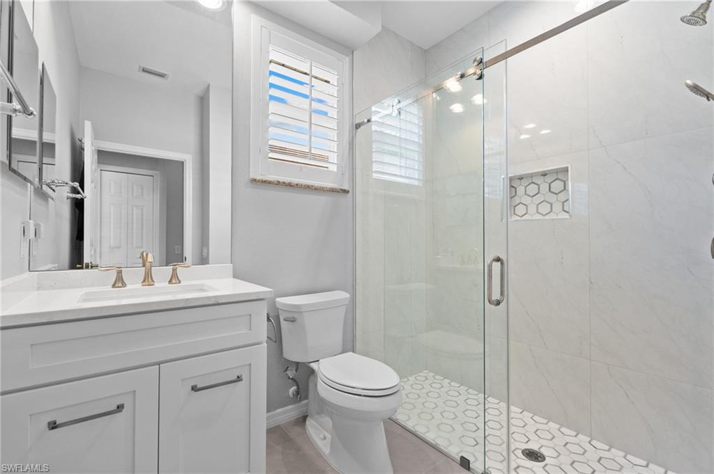 1717 Winding Oaks Way Naples, FL 34109 - Photo 21 of 29 a bathroom with a sink a toilet and shower