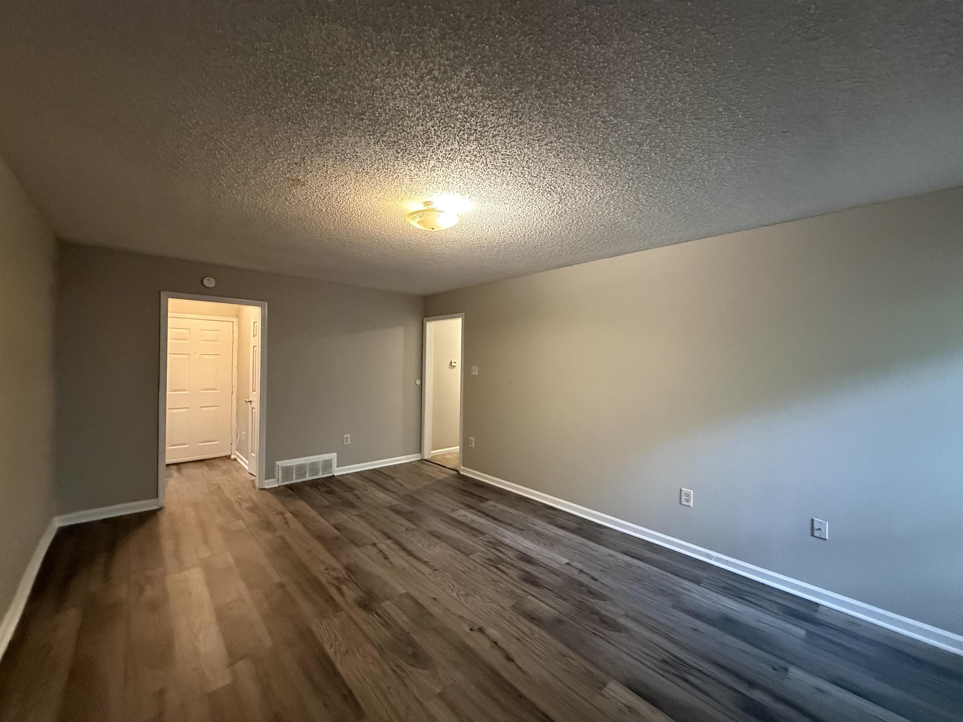 6420 Saginaw Road Memphis, TN 38134 - Photo 4 of 38 Spacious interior featuring wood-finish flooring, neutral wall tones, white baseboards, and a flush mount ceiling light