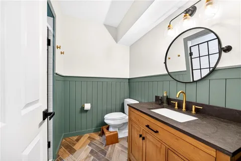 a bathroom with a granite countertop sink a toilet and a mirror