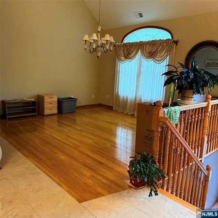 wooden floor in an entryway with a chandelier