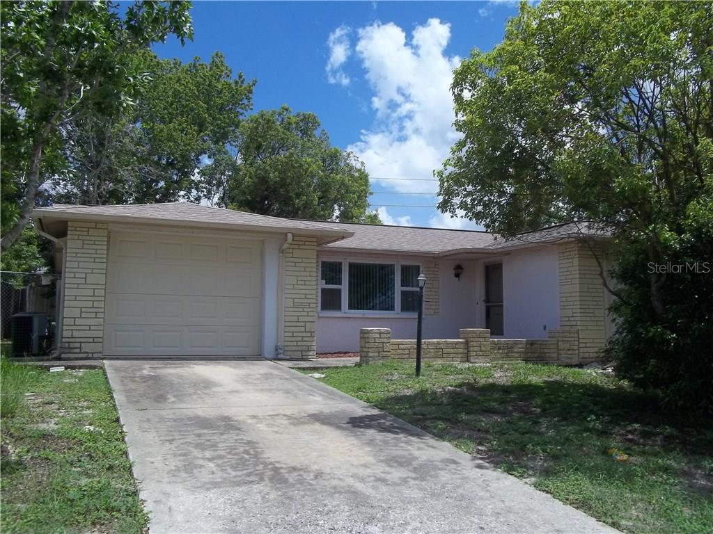 7611 Judith Crescent Port Richey, FL 34668 - Photo 1 of 1 a front view of house with yard and trees
