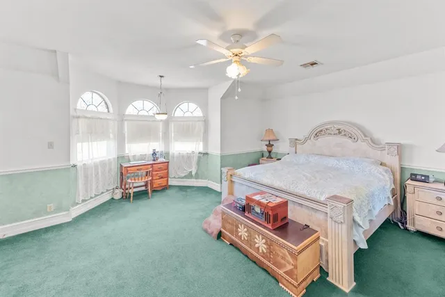 a spacious bedroom with a bed and a chandelier