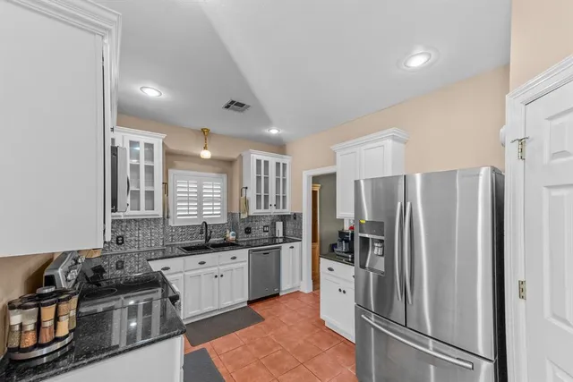 a kitchen with stainless steel appliances granite countertop a refrigerator stove and sink