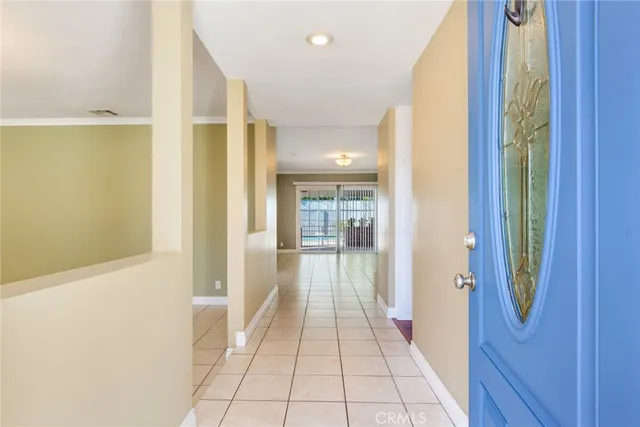 a hallway with wooden floor windows and chandelier
