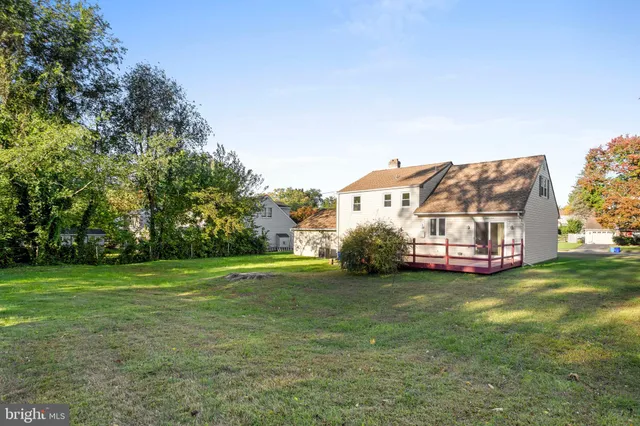 a view of a house with a big yard and large trees