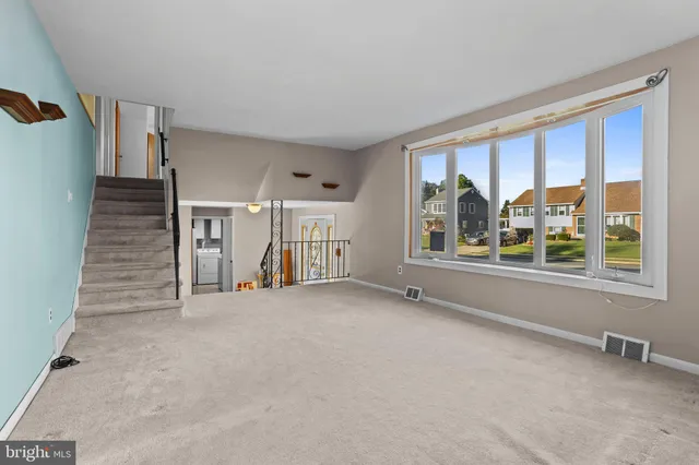 a view of an empty room with a window and stairs