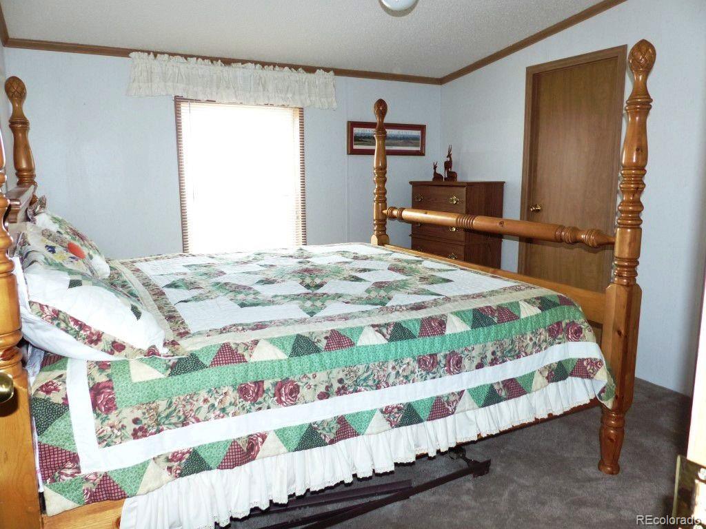 985 Prairie Road Westcliffe, CO 81252 - Photo 16 of 35 a bedroom with a bed and a dresser in it