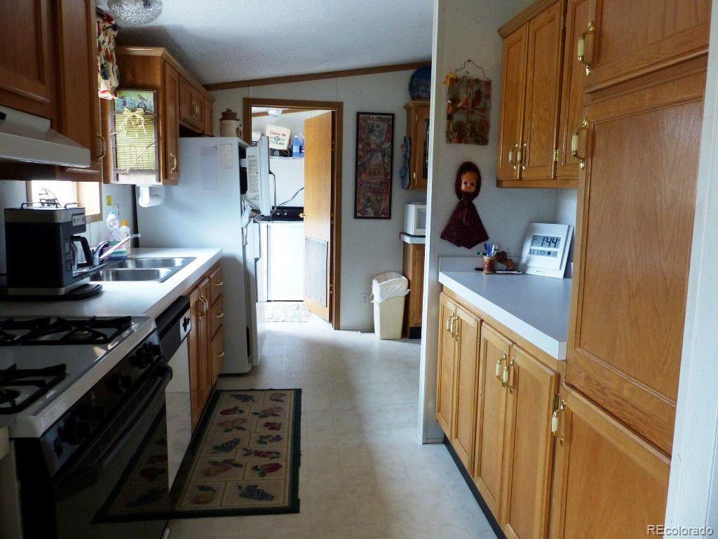 985 Prairie Road Westcliffe, CO 81252 - Photo 28 of 35 a kitchen with stainless steel appliances granite countertop a stove a sink and a refrigerator
