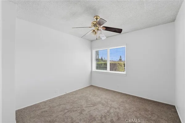 an empty room with windows and fan