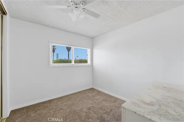 an empty room with a chandelier fan