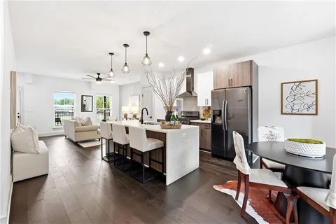 a living room with stainless steel appliances kitchen island furniture and a wooden floor