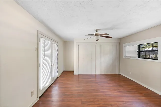 a view of a livingroom with wooden floor and a ceiling fan