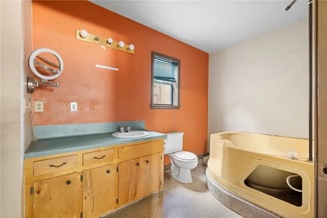 a bathroom with a toilet a sink and mirror