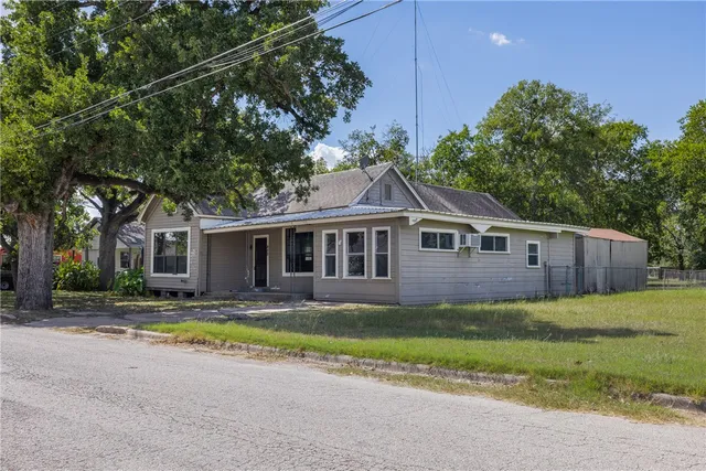 a front view of a house with yard and trees
