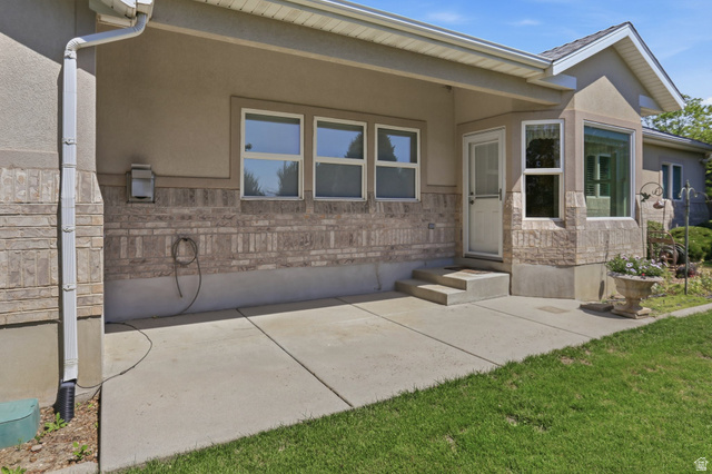 2190 750 West Perry, UT 84302 - Photo 7 of 42 Concrete patio area with a stucco and stone veneer exterior
