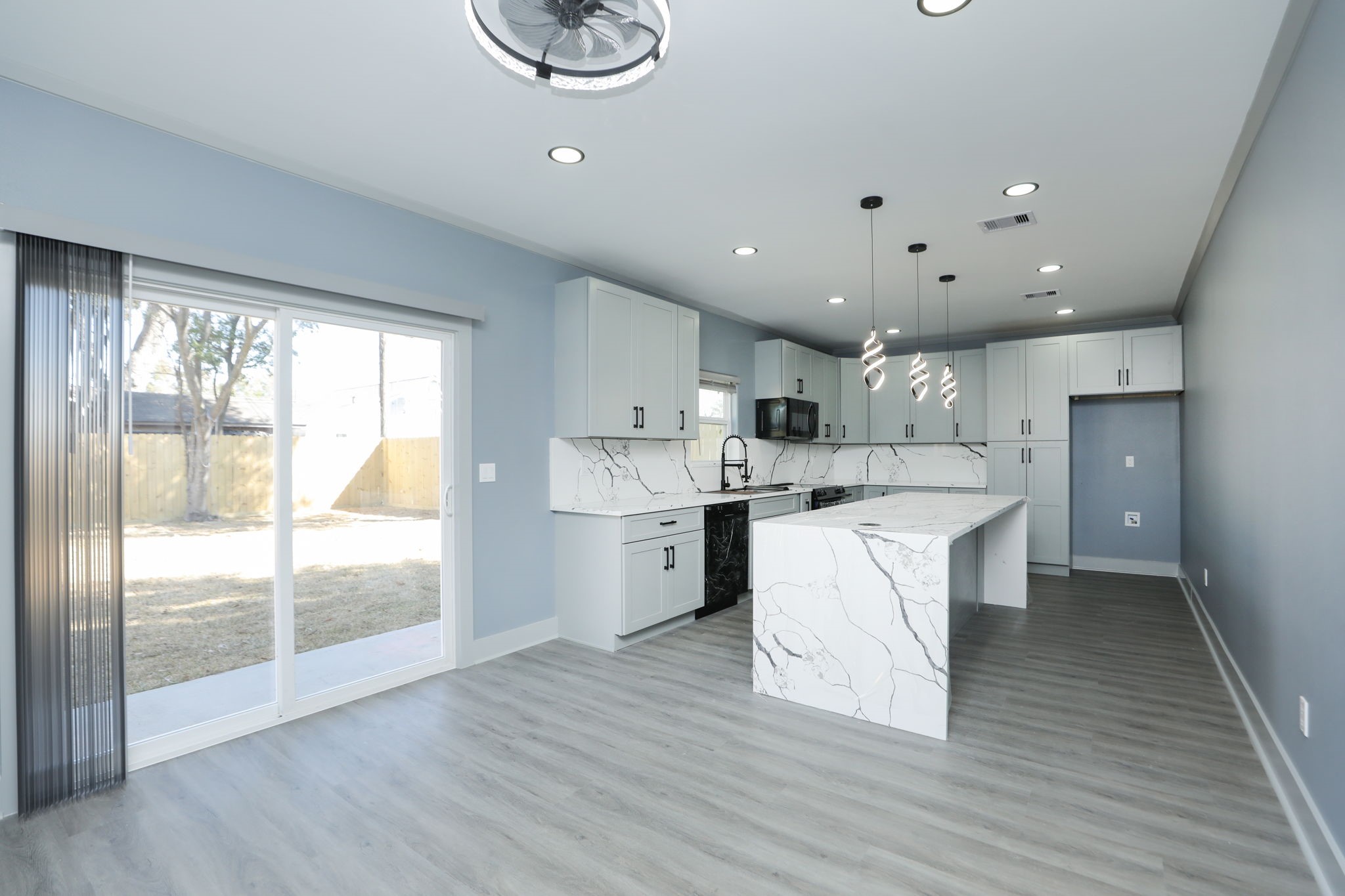 4047 Juliet Street Houston, TX 77087 - Photo 10 of 38 a large kitchen with stainless steel appliances wooden floors and white cabinets