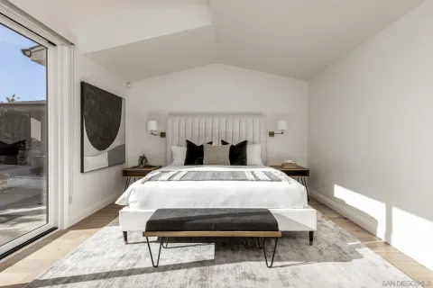 a bedroom with a bed a mirror and lamp