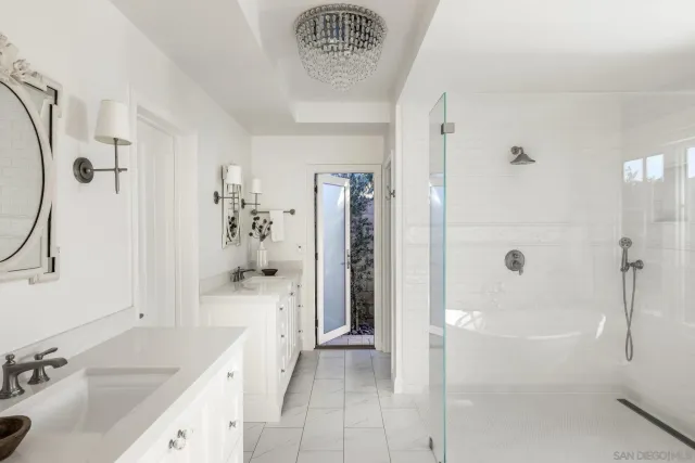 a bedroom with a bed a mirror and a large window