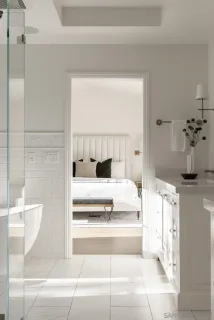 a living room with a white furniture and a potted plant