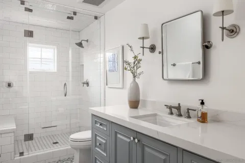 a bathroom with a granite countertop sink toilet and shower