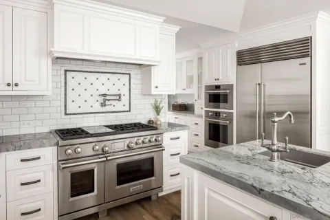 a kitchen with granite countertop a stove oven and sink