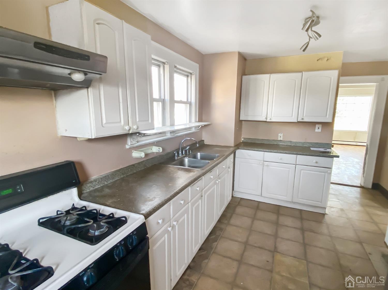 3181 Washington Road Sayreville, NJ 08859 - Photo 6 of 18 a kitchen with a sink stove and cabinets