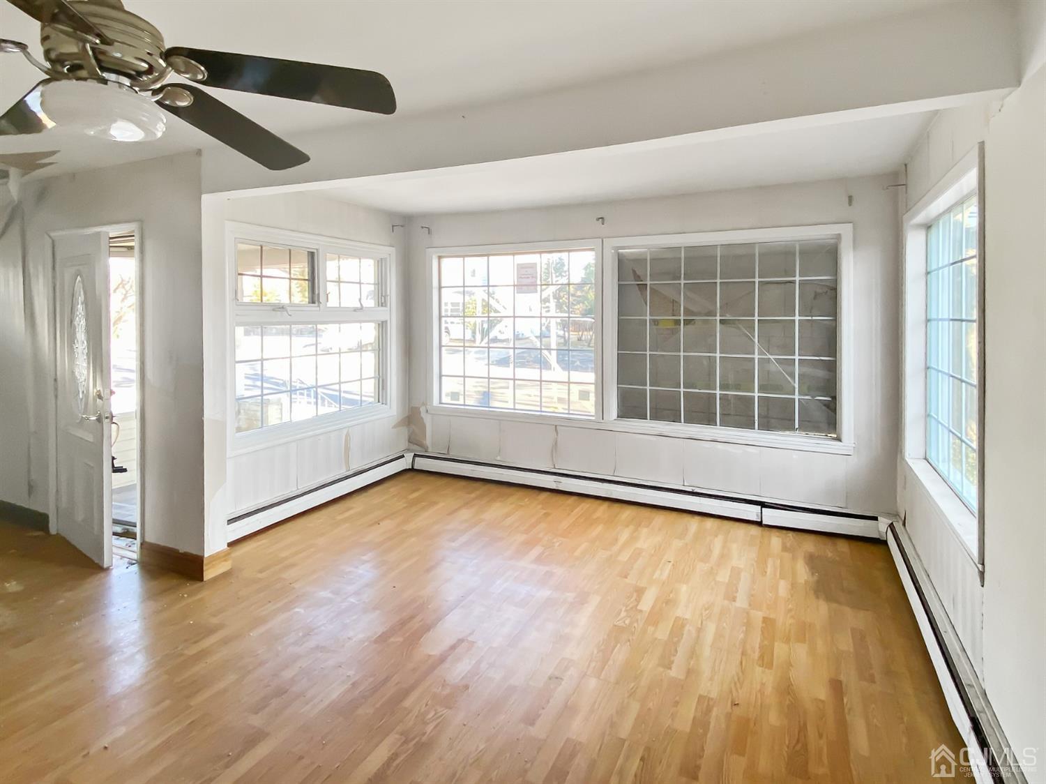 3181 Washington Road Sayreville, NJ 08859 - Photo 7 of 18 an empty room with wooden floor and windows