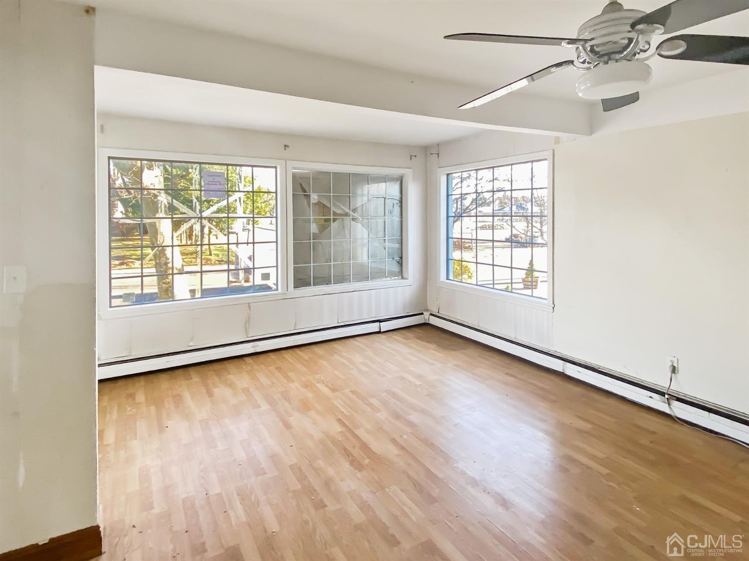 3181 Washington Road Sayreville, NJ 08859 - Photo 9 of 18 an empty room with wooden floor and windows