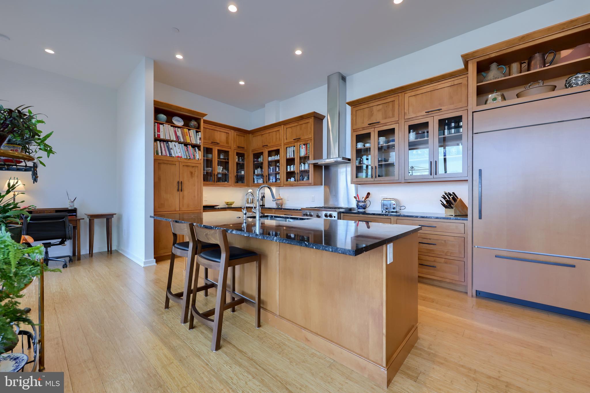 101 North Queen Street, Unit 404 Lancaster, PA 17603 - Photo 15 of 30 a kitchen with stainless steel appliances granite countertop a table chairs stove a sink and a refrigerator