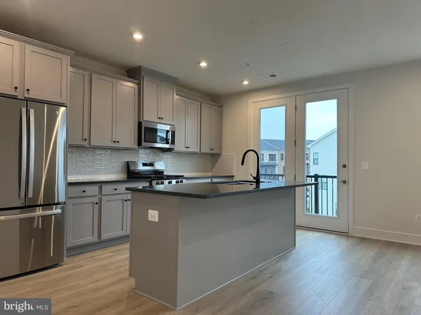 a kitchen with stainless steel appliances granite countertop a refrigerator sink and microwave
