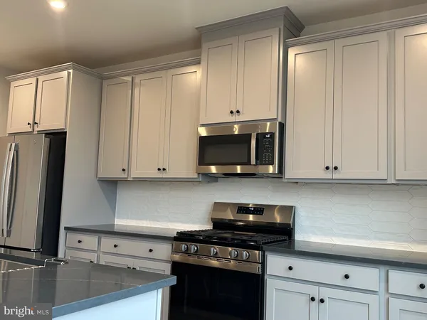 a kitchen with stainless steel appliances granite countertop a sink a stove and a refrigerator