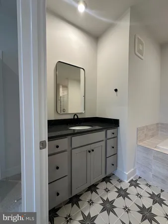 a bathroom with a granite countertop sink and a mirror