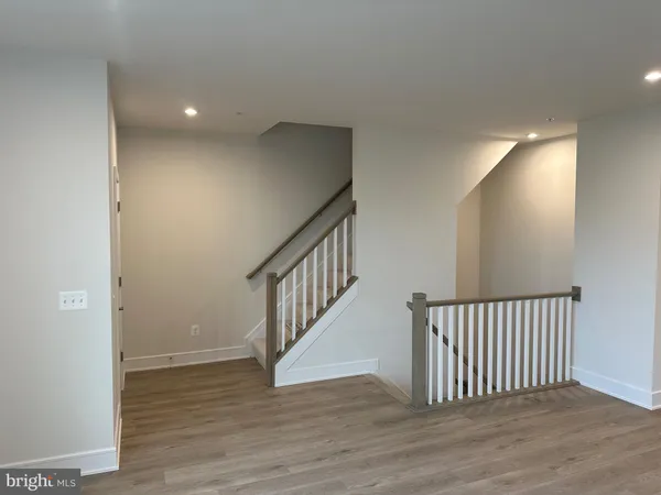 a view of a hallway with wooden floor and stairs