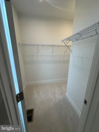 a view of an empty room with windows and closet