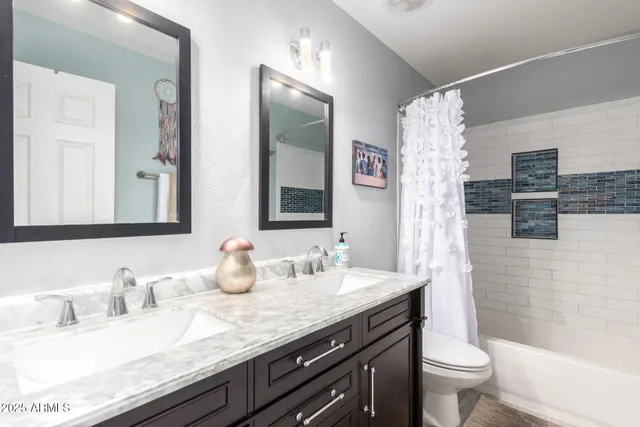 a bathroom with a granite countertop sink mirror and toilet