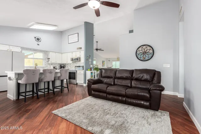 a living room with furniture wooden floor and a clock