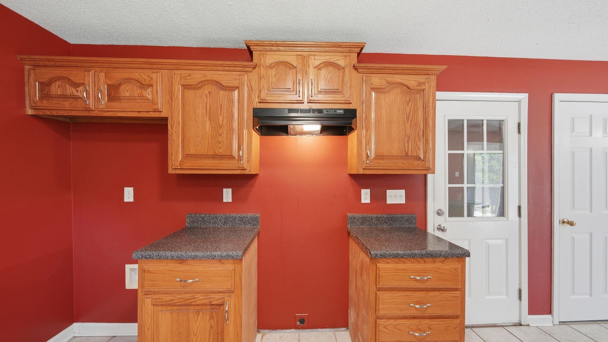 217 Rae Drive Munford, TN 38058 - Photo 16 of 40 Kitchen featuring wood cabinetry, speckled countertops, an integrated range hood and pantry.
