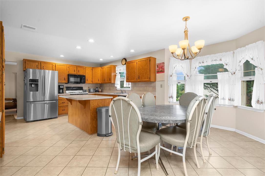 1255 Spring Road Easton, PA 18040 - Photo 6 of 23 Rich wood cabinetry and tile flooring define this spacious open kitchen and dining area.