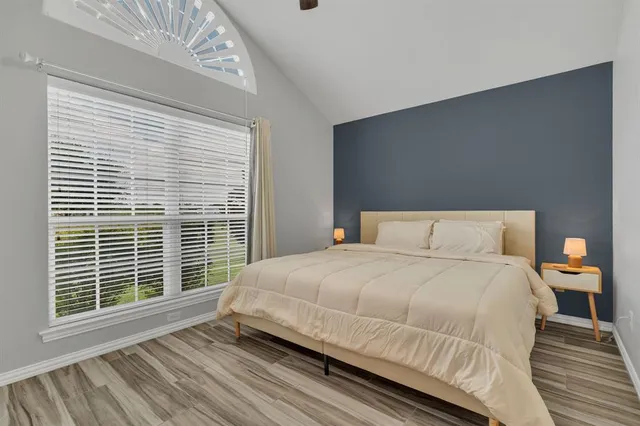 a bedroom with a bed and a large window