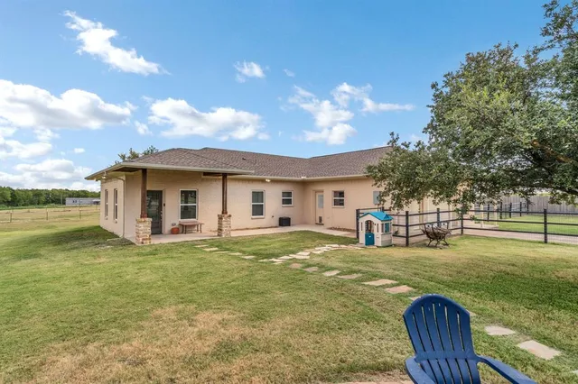 a view of a house with a big yard and a large tree