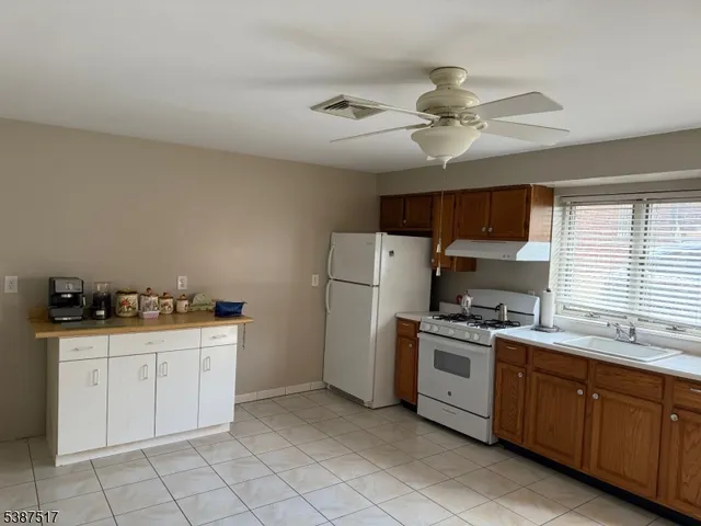 a kitchen with stainless steel appliances a stove a sink and white cabinets